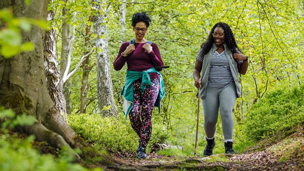 Two women walking through a woodland